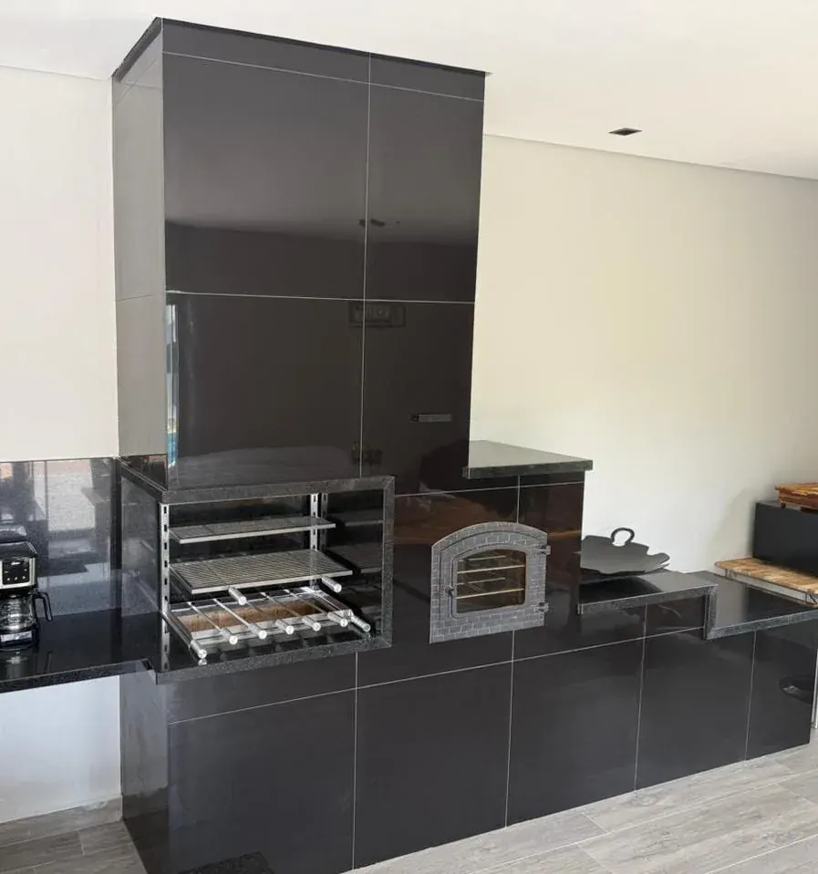 Conjunto 3 em 1 com churrasqueira, forno de ferro e fogão a lenha em balanço, revestido em porcelanato.